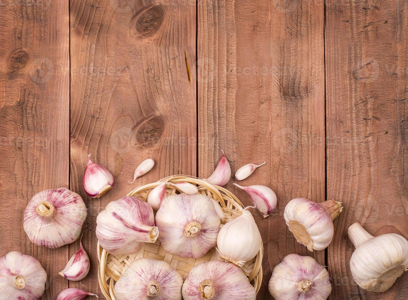 Cloves of garlic on wooden background photo