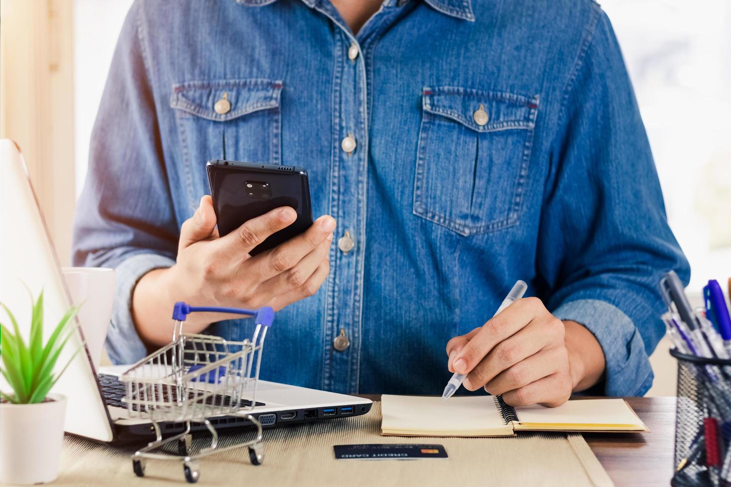 el hombre de negocios contesta el teléfono feliz después de un nuevo pedido del cliente, el dueño del negocio que trabaja en el empaque de la oficina en el fondo, el comercio electrónico de compras en línea o el concepto de trabajo independiente. foto