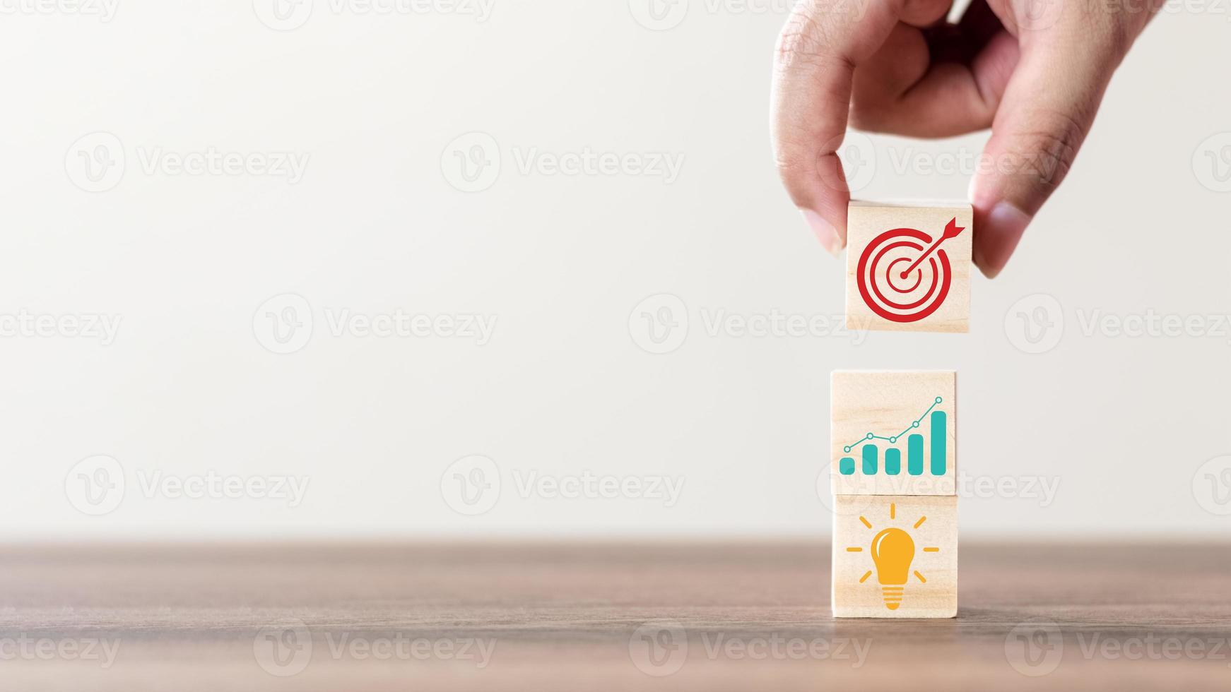 Concept of business strategy and future sustainable business finance action plan. Businessman hand putting wood cube block on top with icon. photo