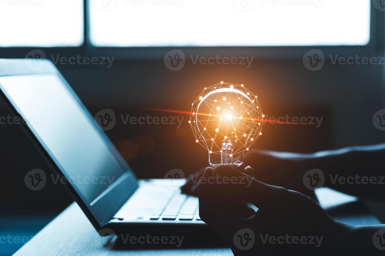 Hand holding a light bulb and working on a laptop computer, Concept of inspirational ideas creativity and technological innovation of the future. photo
