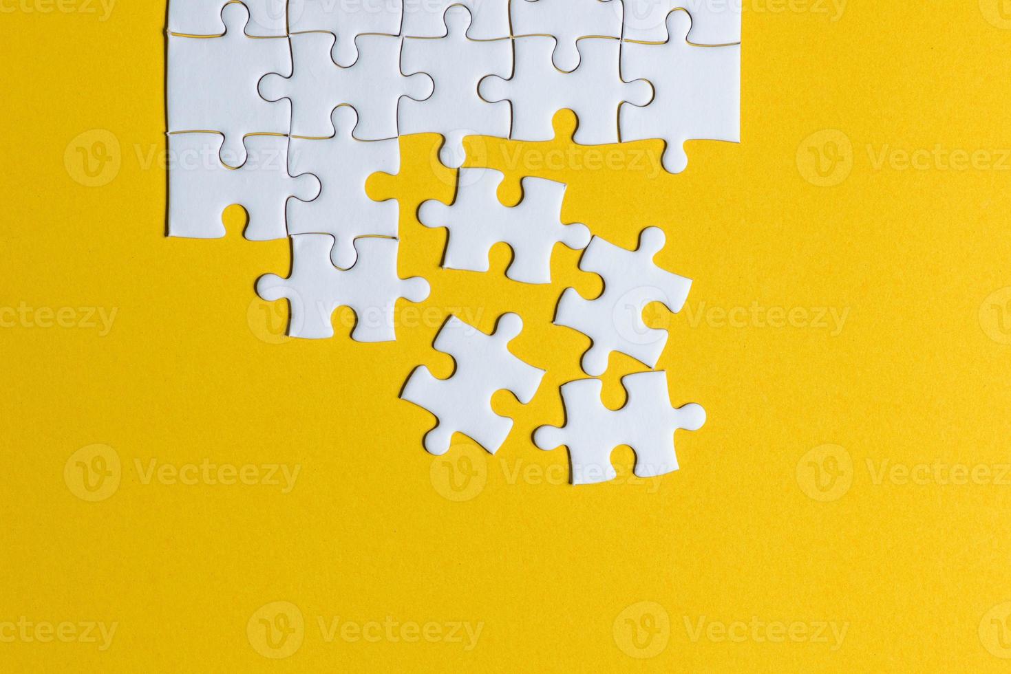 Jigsaw puzzles placed on a yellow background Creative concept with copy space photo