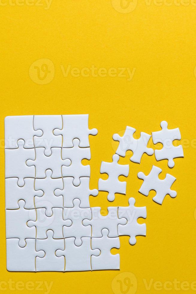 Jigsaw puzzles placed on a yellow background Creative concept with copy space photo