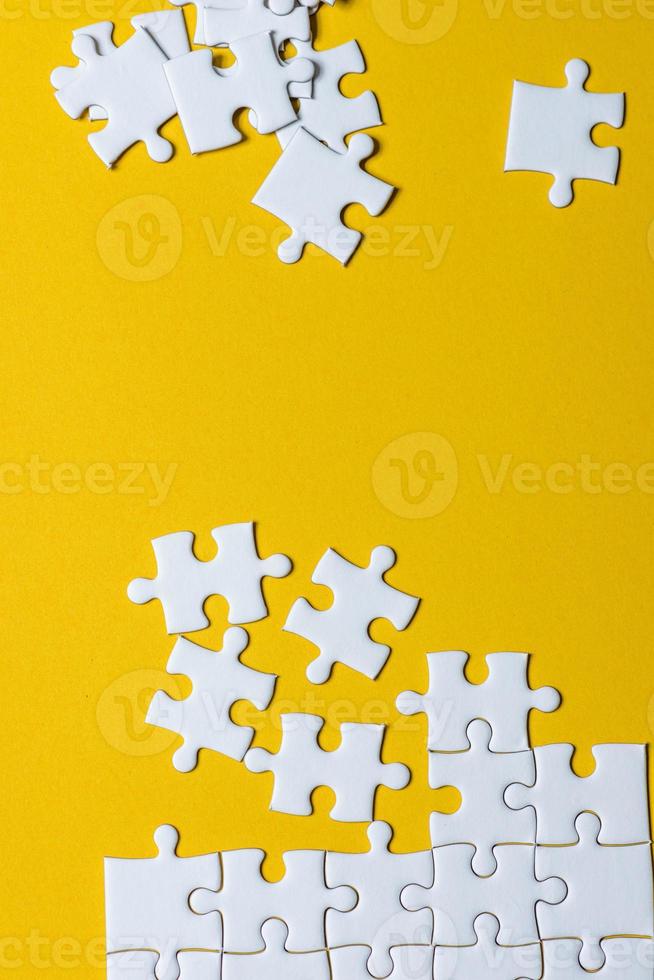 Jigsaw puzzles placed on a yellow background Creative concept with copy space photo