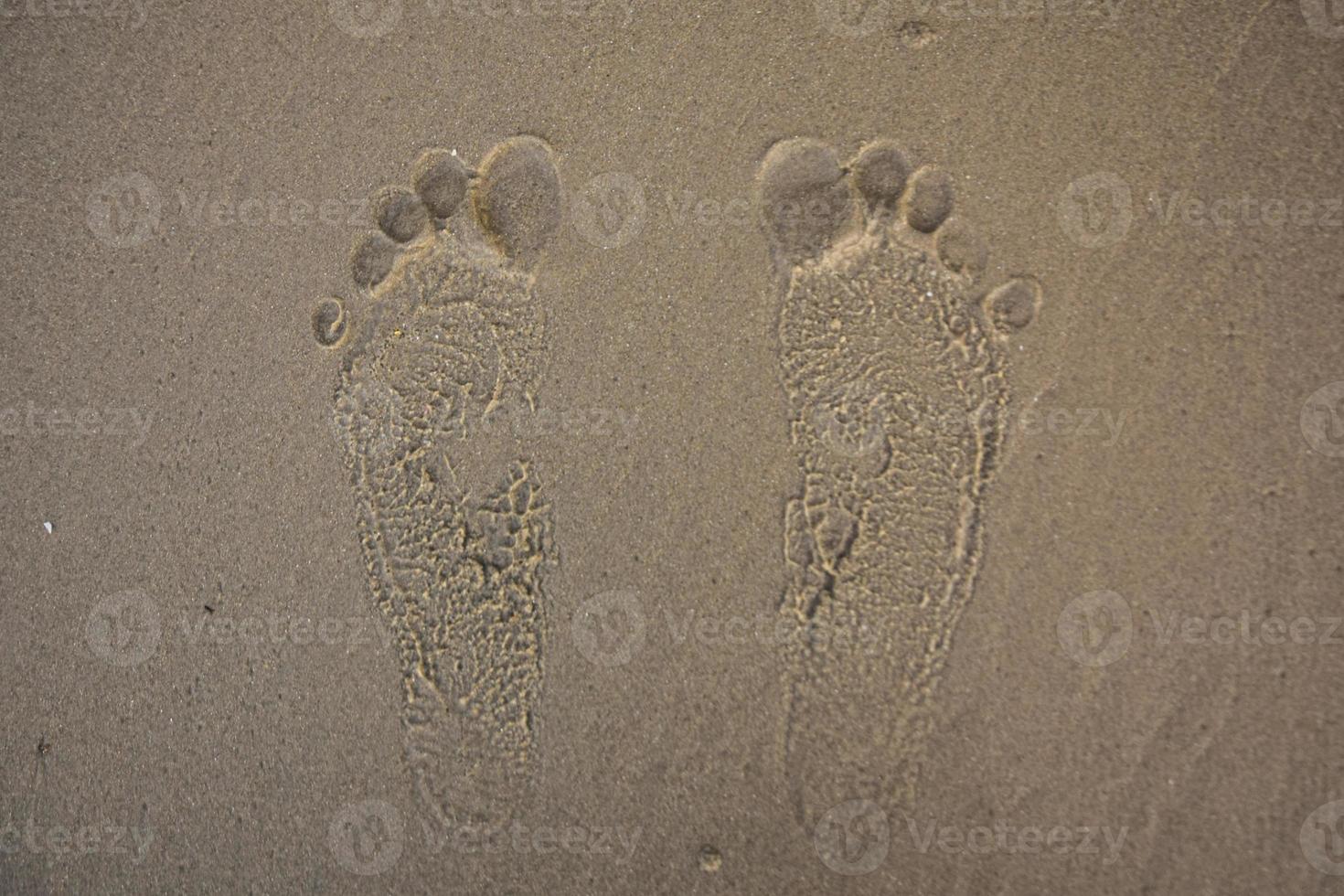 Footprints on the sand Rayong beach in Thailand photo