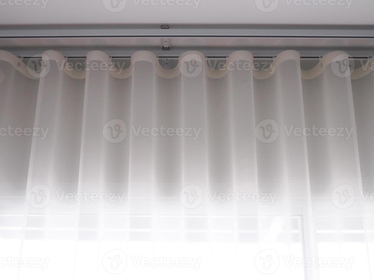 White sheer curtains with translucent fabric hanging on window photo