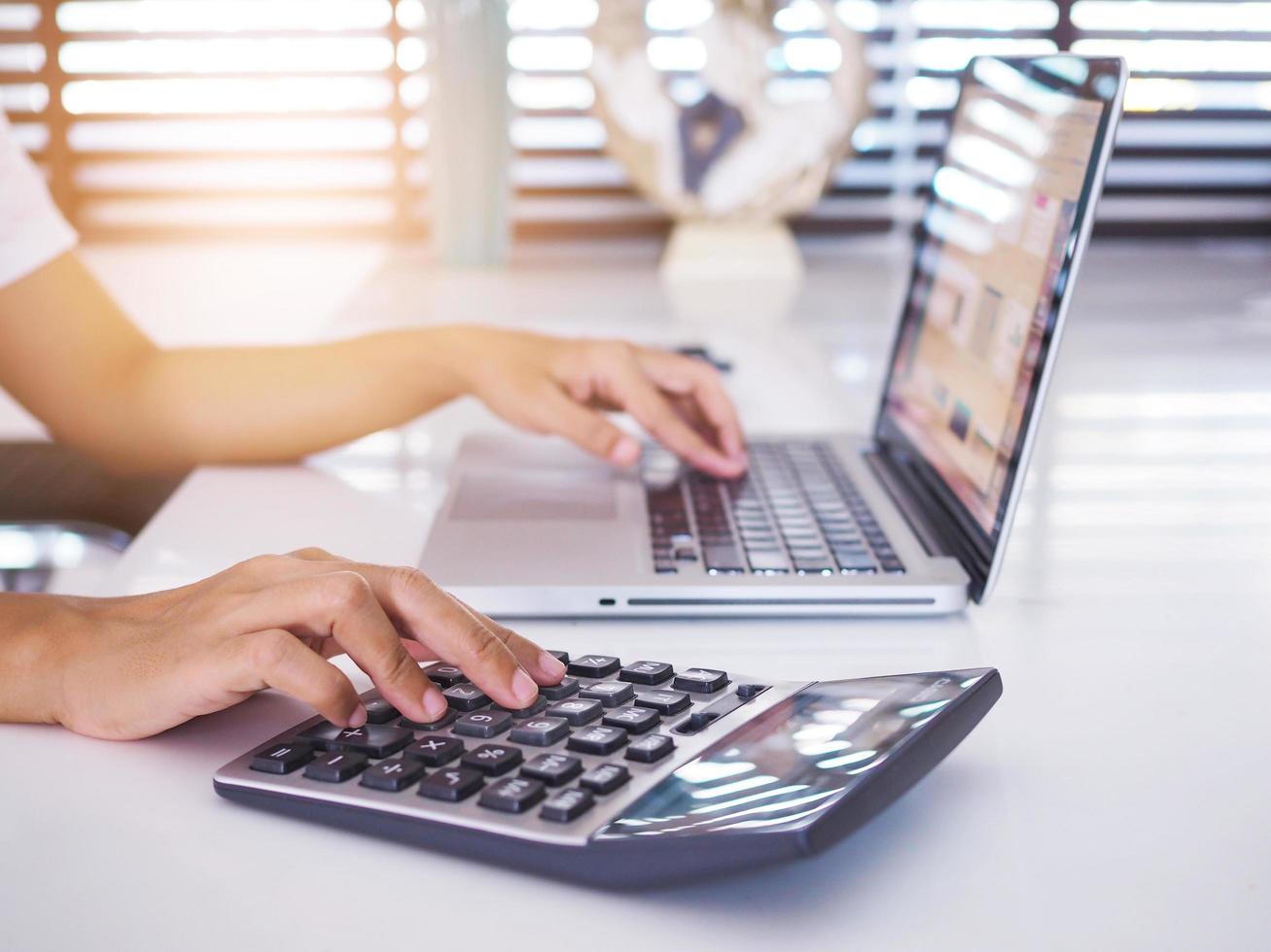 quédese en casa con el negocio financiero trabajando con computadoras portátiles y calculadoras. foto