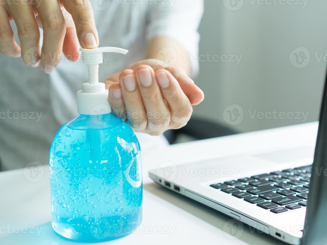 The hand of a middle-aged man who is using alcohol gel to clean his hands. photo