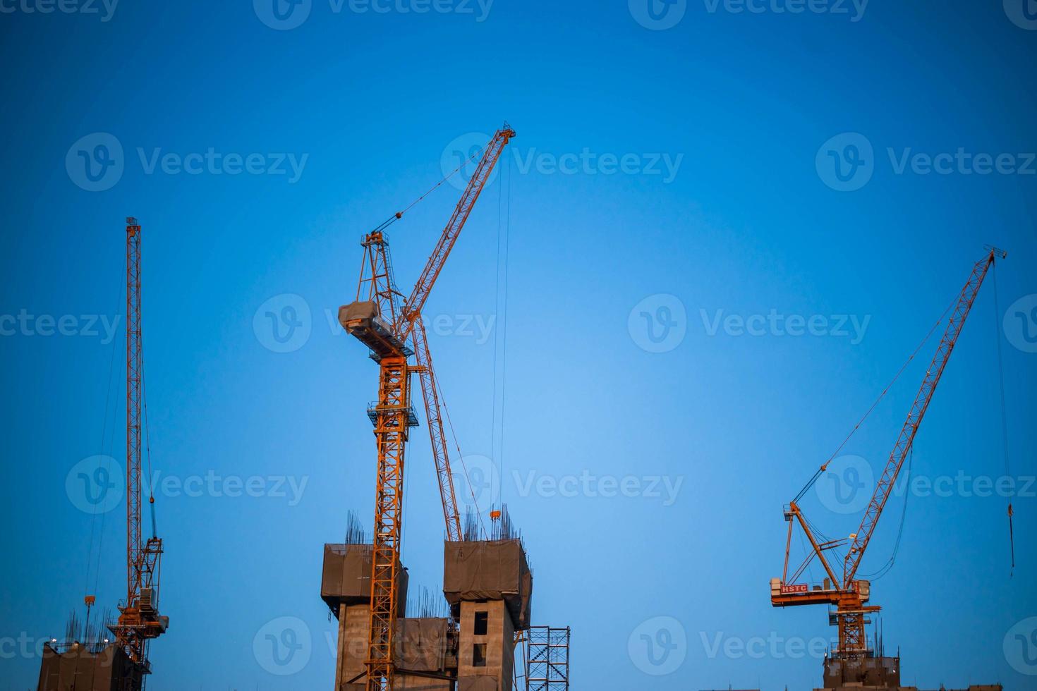 Construction crane is working building in the blue sky. photo