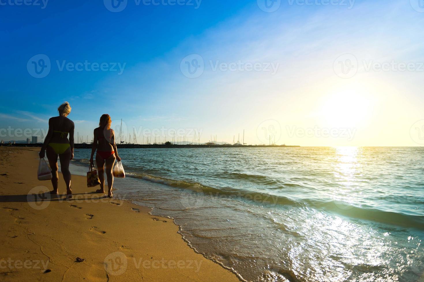 unidentified Foreign tourists wear bikinis walk on the beach sand Pattaya Thailand. photo