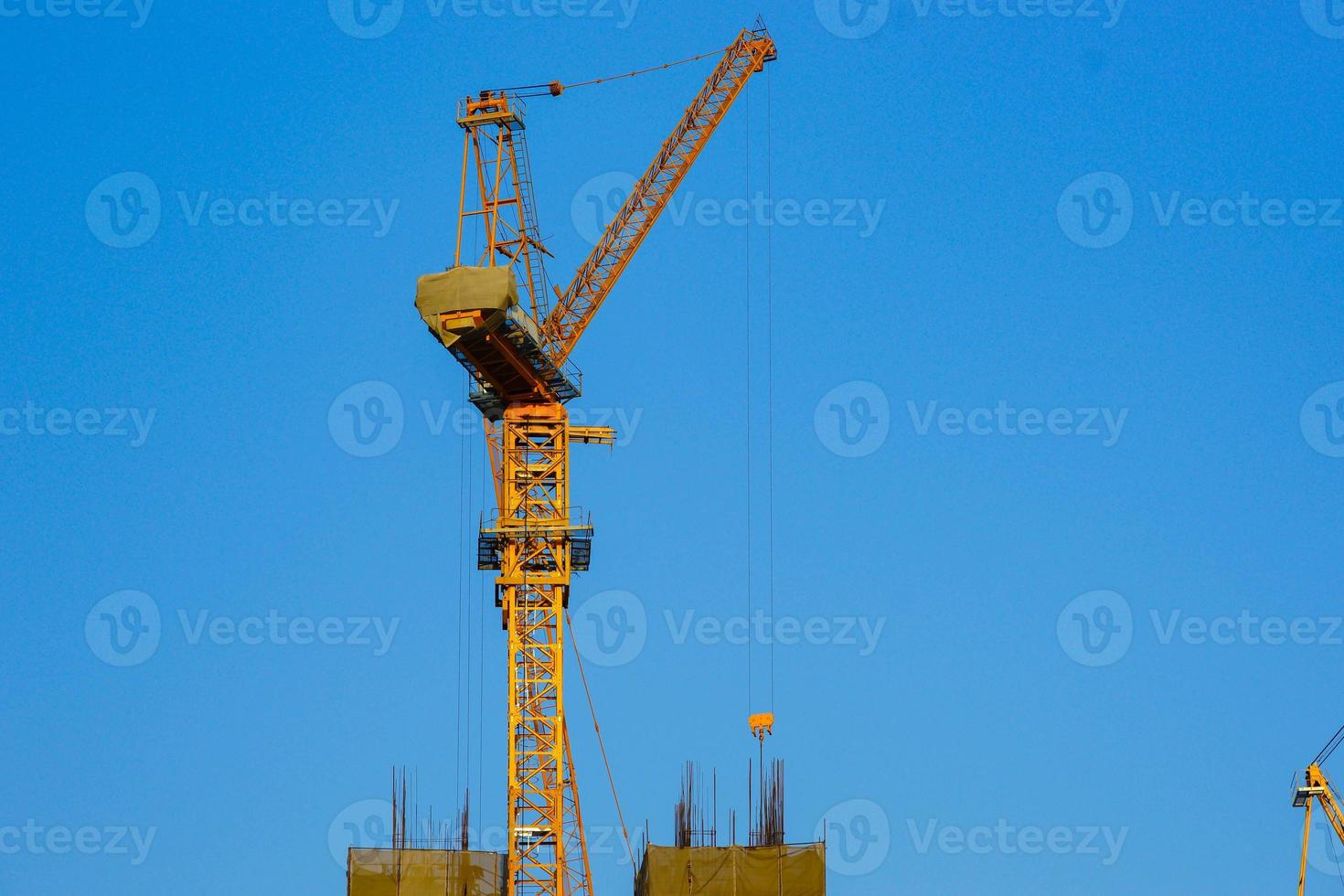 Construction crane is working building in the blue sky. photo