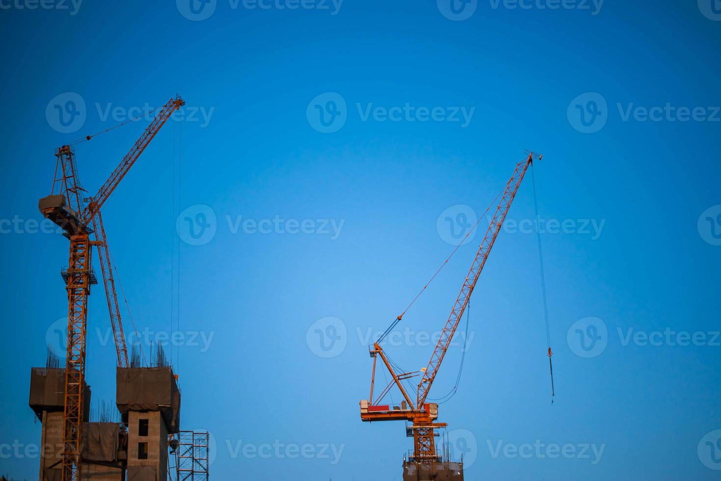 Construction crane is working building in the blue sky. photo