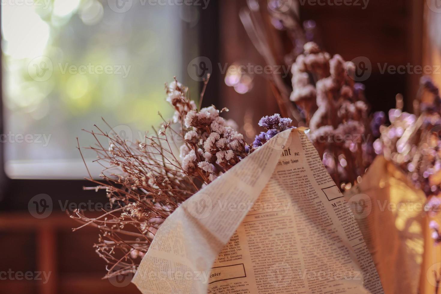 Soft focus of dried flowers in newspaper wrap for decoration. photo