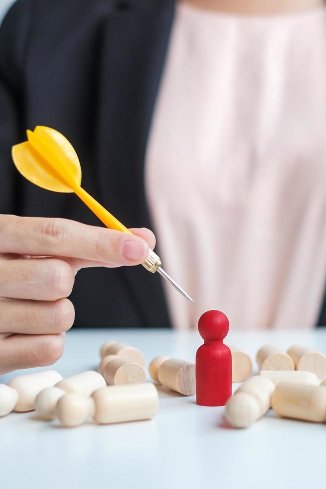 Hand holding dart over red people.Goal, target, aim, objective, leadership, Business and marketing concept photo