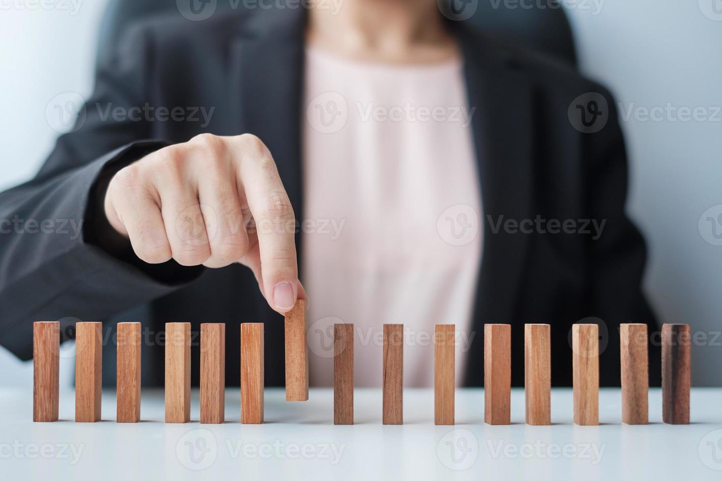 mujer de negocios tirando de la mano al hombre líder de madera de la multitud del bloque. personas tóxicas, gestión de recursos humanos, contratación, trabajo en equipo y conceptos de liderazgo foto