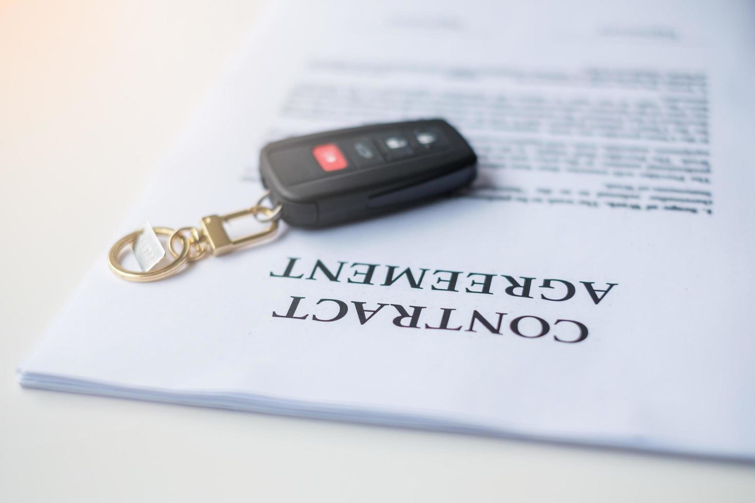 contract document with car and remote key. buy and sale, insurance, rental and contract agreement concepts photo