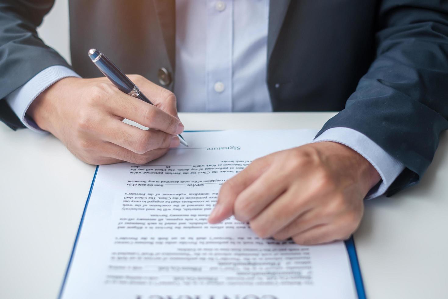 hombre de negocios que firma los documentos del contrato después de leer, el hombre sostiene la pluma y aprueba el informe comercial. acuerdo de contrato, asociación y conceptos de trato foto