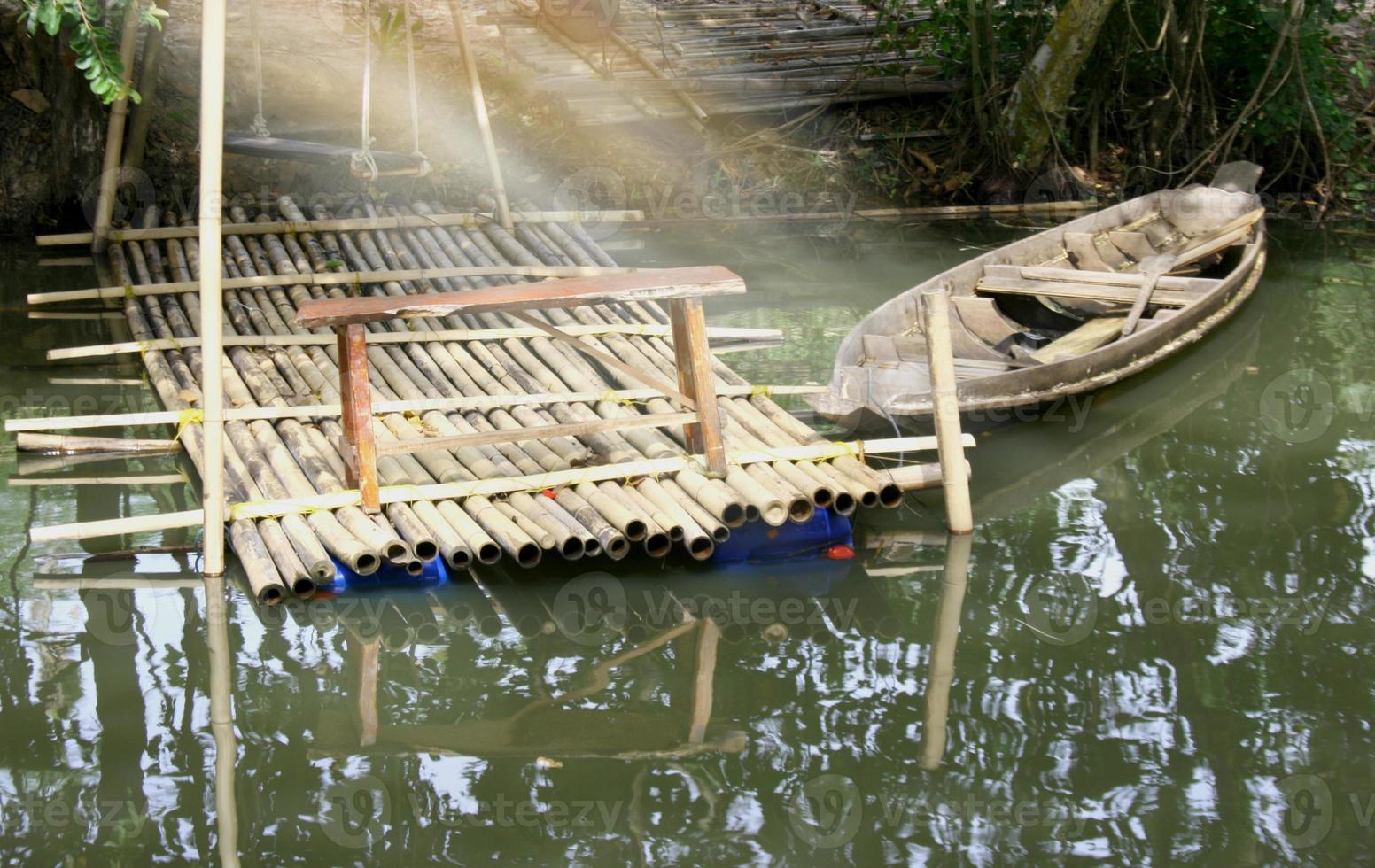 old wooden rowboat moored at the edge of a lake photo