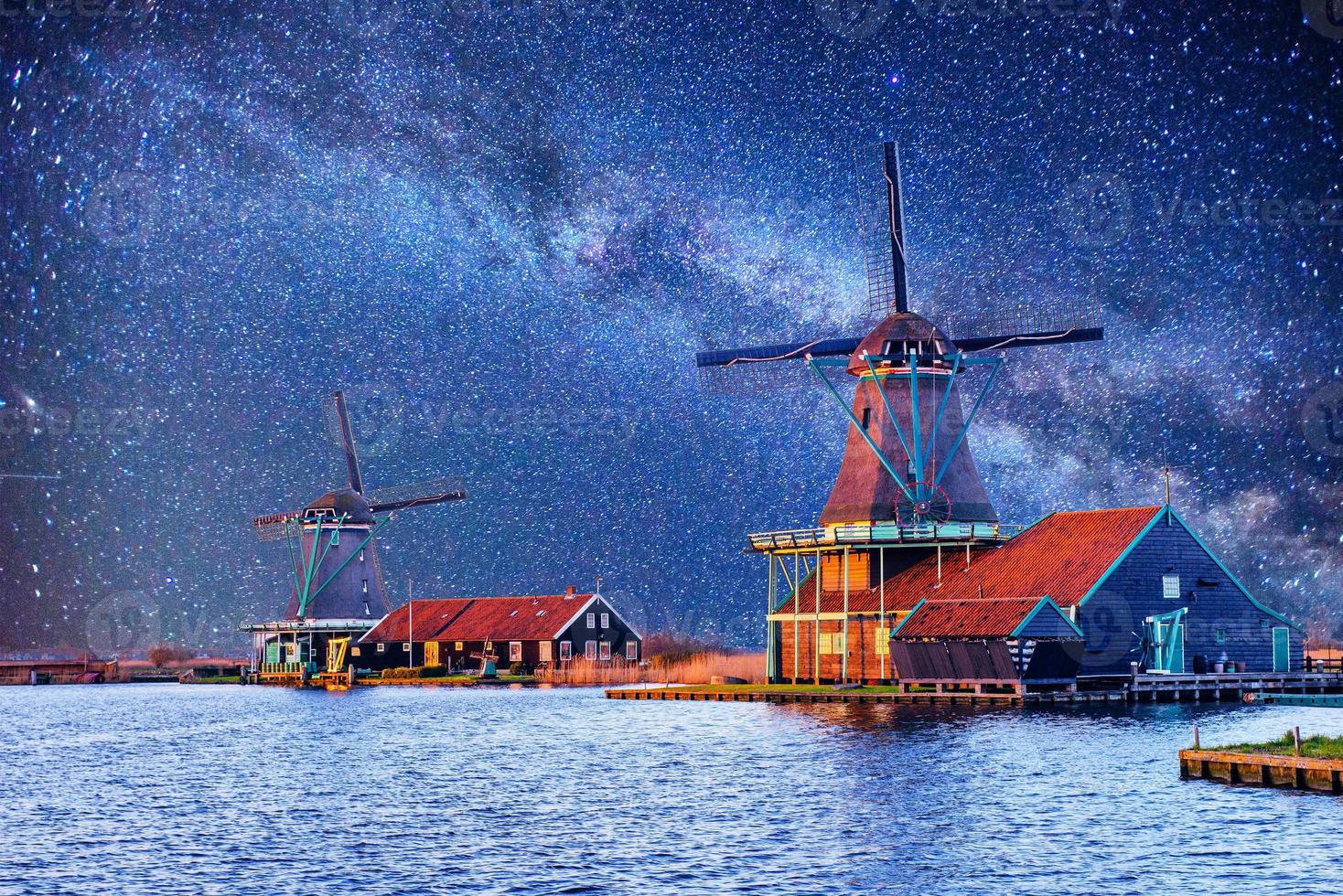 cielo estrellado sobre molinos de viento holandeses desde el canal en rotterdam foto