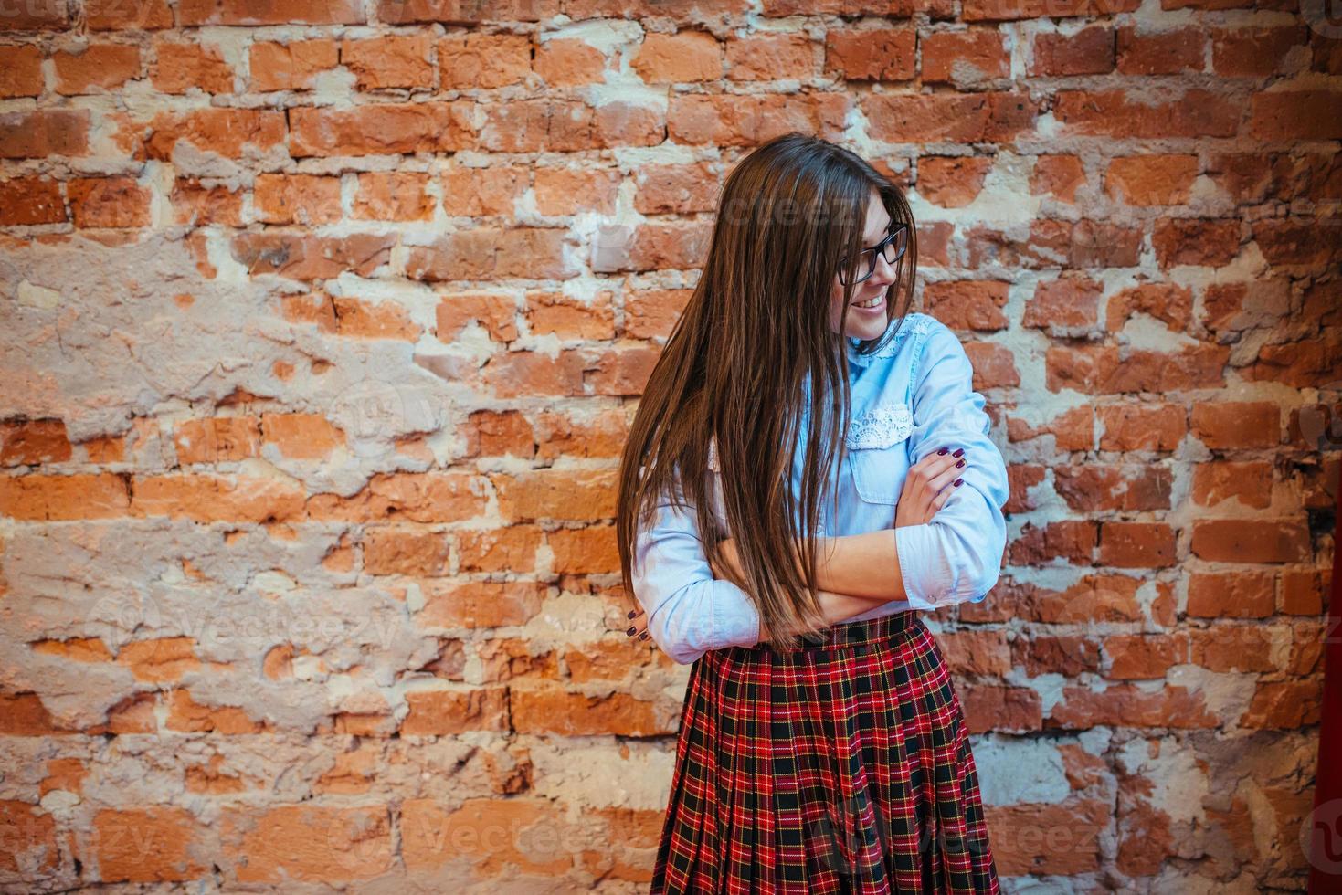 Beautiful young woman stands near the old brick wall. Youth styl photo