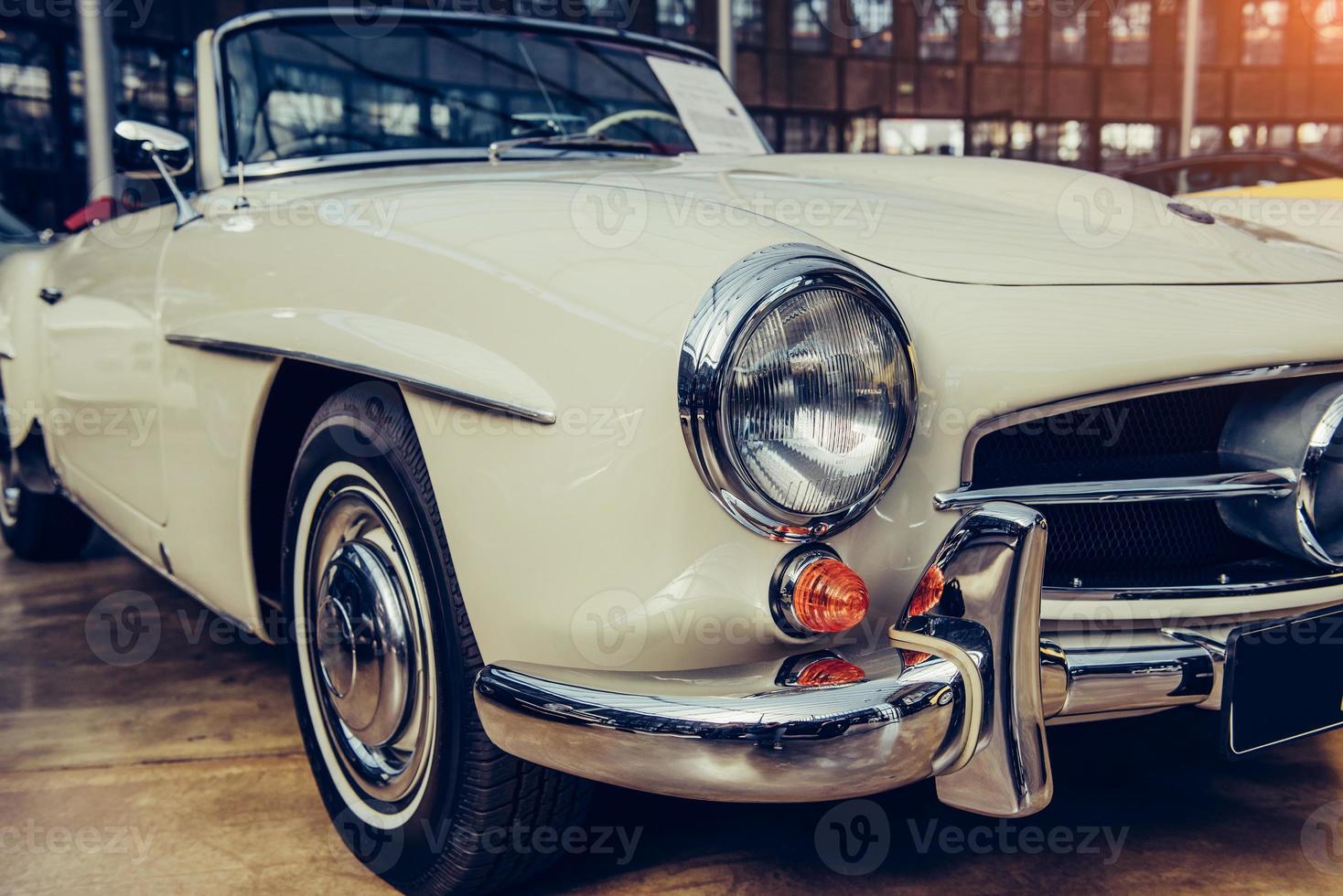 closeup of the headlights and front bumper on  vintage automobile photo