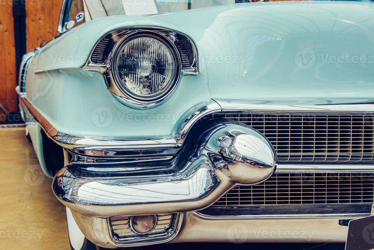 closeup of the headlights and front bumper on  vintage automobile photo