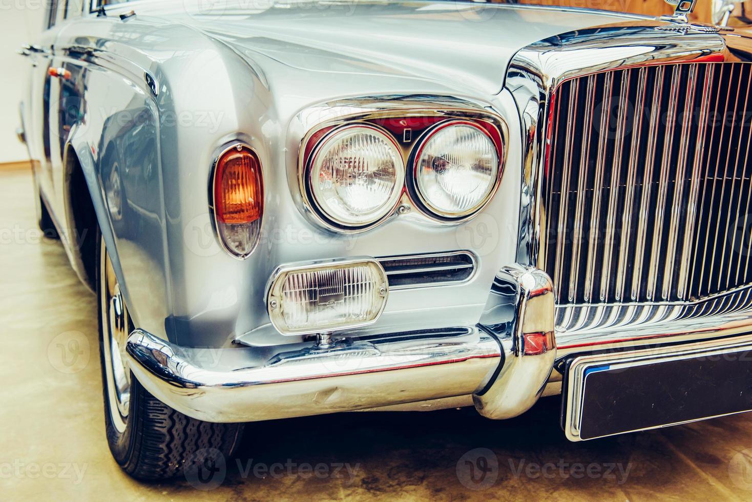 closeup of the headlights and front bumper on  vintage automobile photo