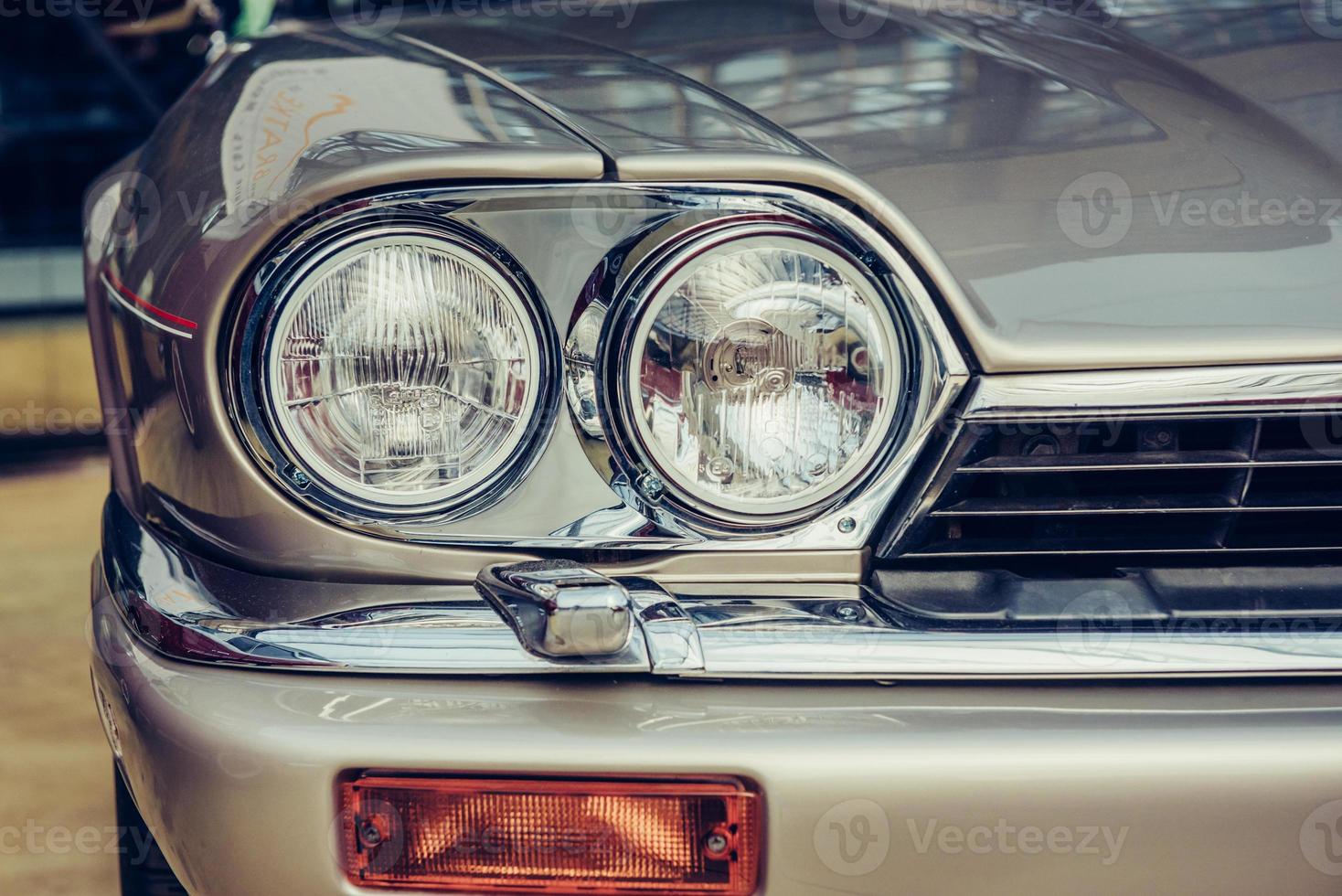 closeup of the headlights and front bumper on  vintage automobile photo