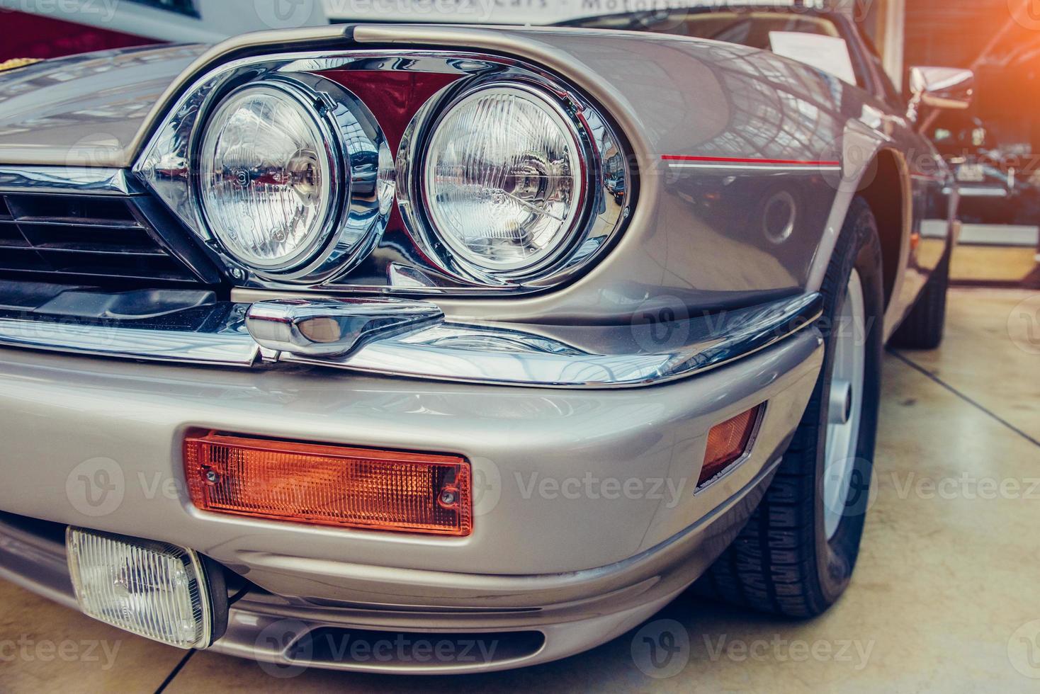 closeup of the headlights and front bumper on vintage automobile photo