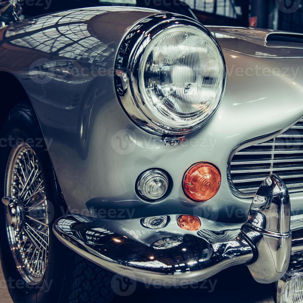 closeup of the headlights and front bumper on  vintage automobile photo