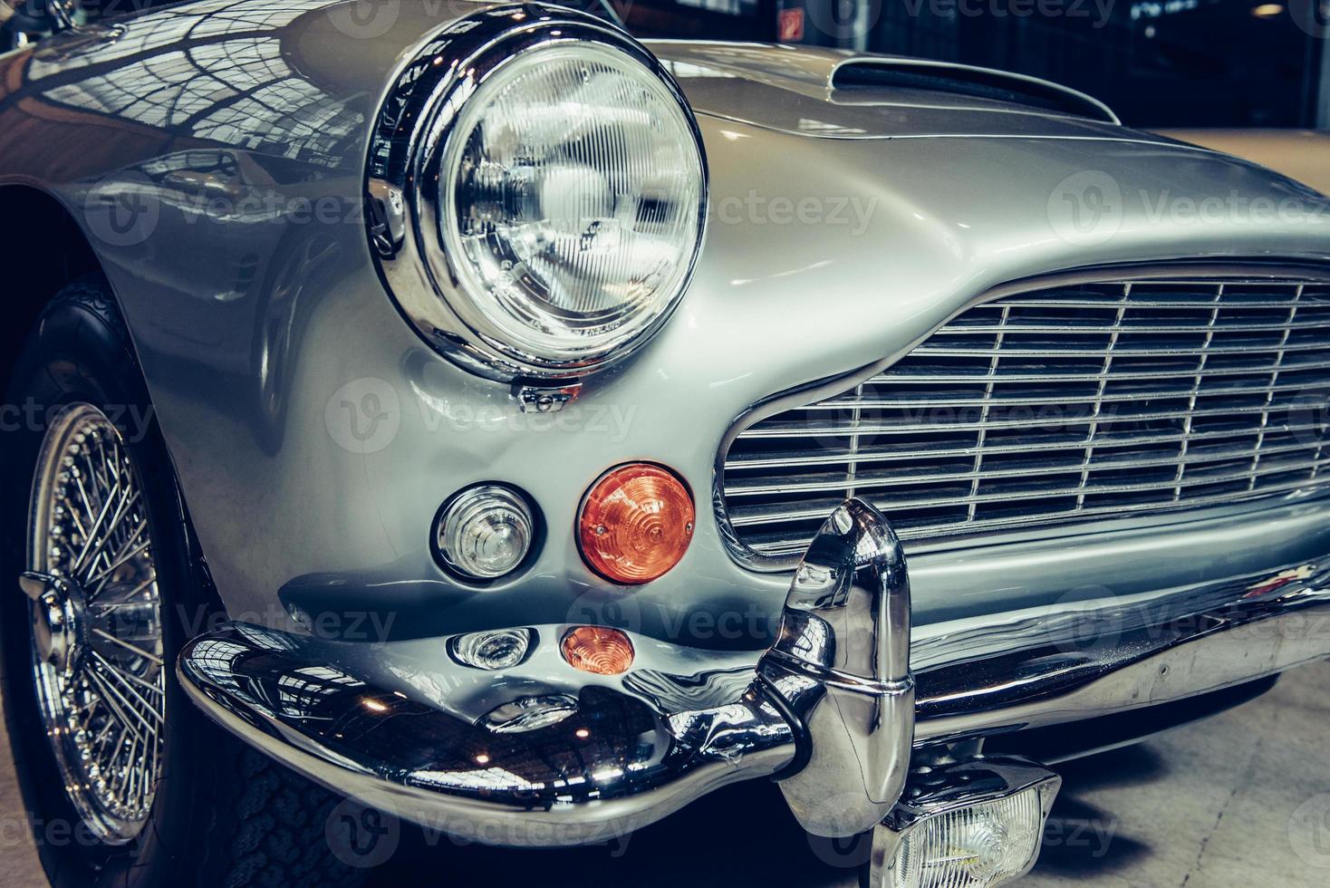 closeup of the headlights and front bumper on  vintage automobile photo