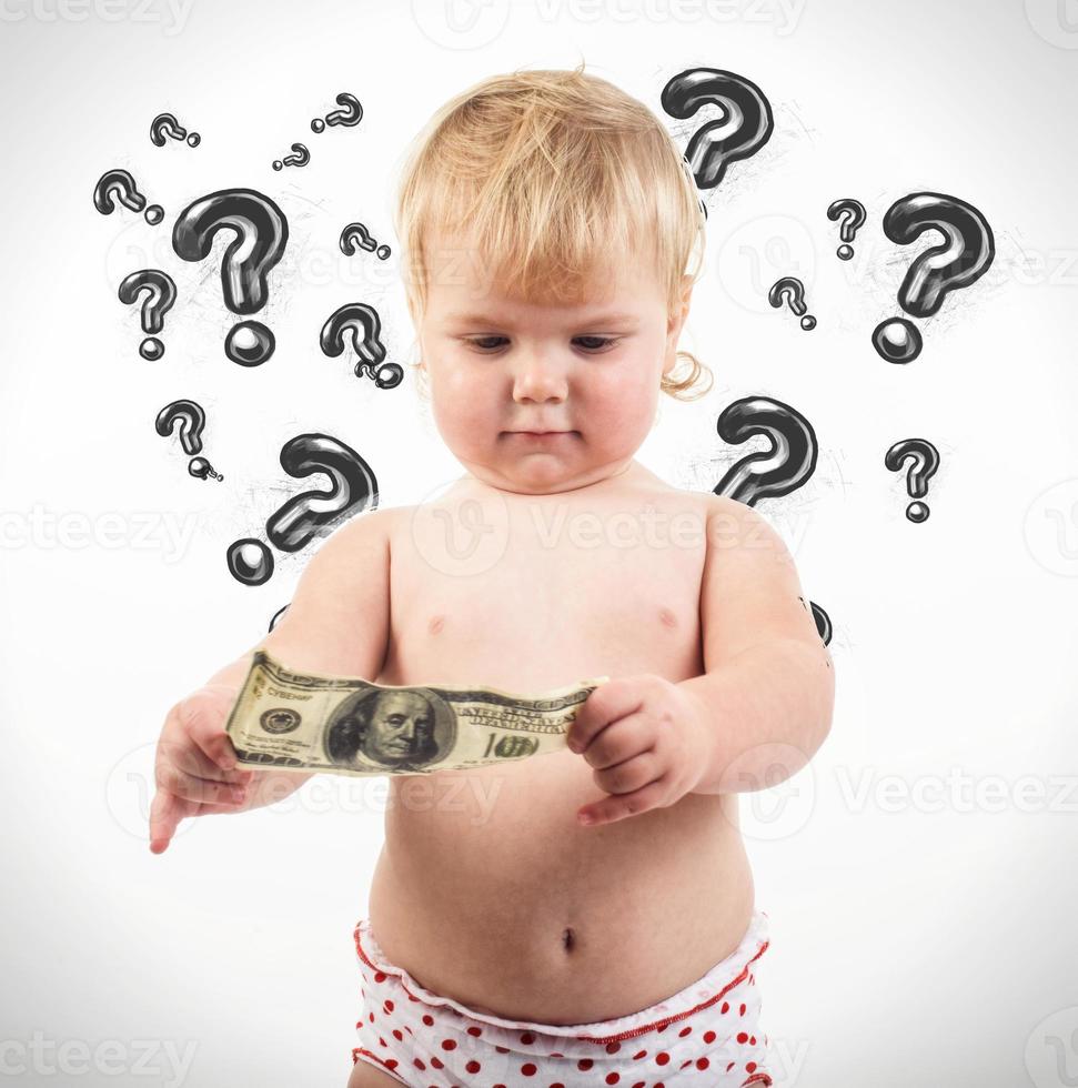 Child examines 100 dollar bill. photo