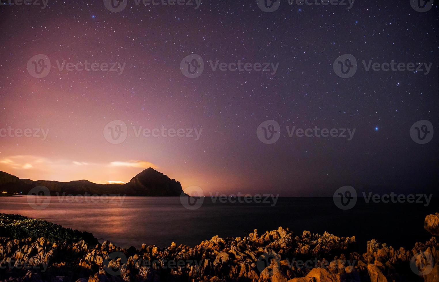 The starry sky above rocky mountains. photo