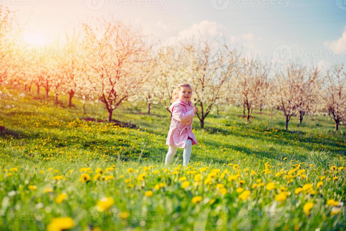 niño corriendo al aire libre árboles en flor. foto