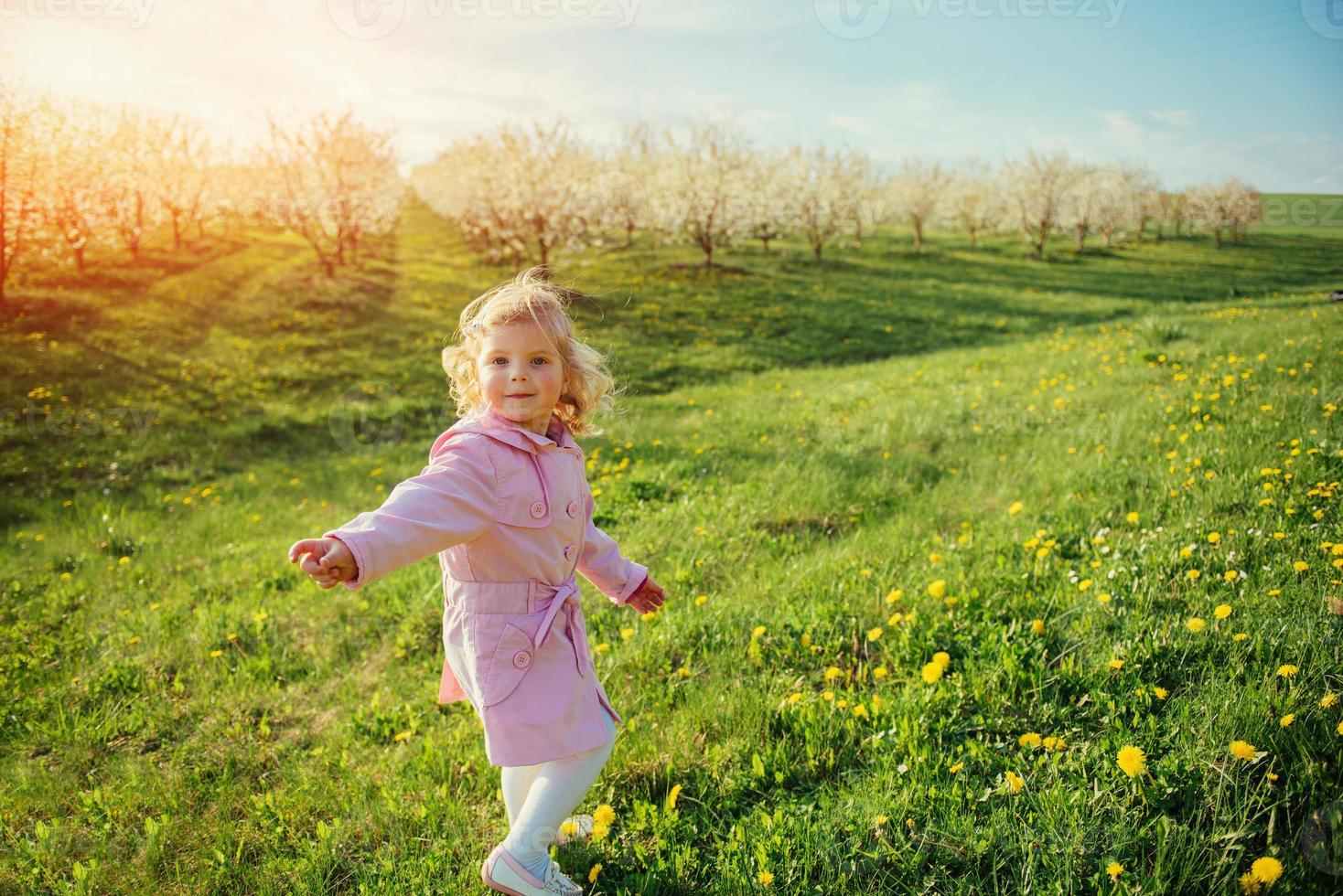 niño juega en el césped de primavera. foto