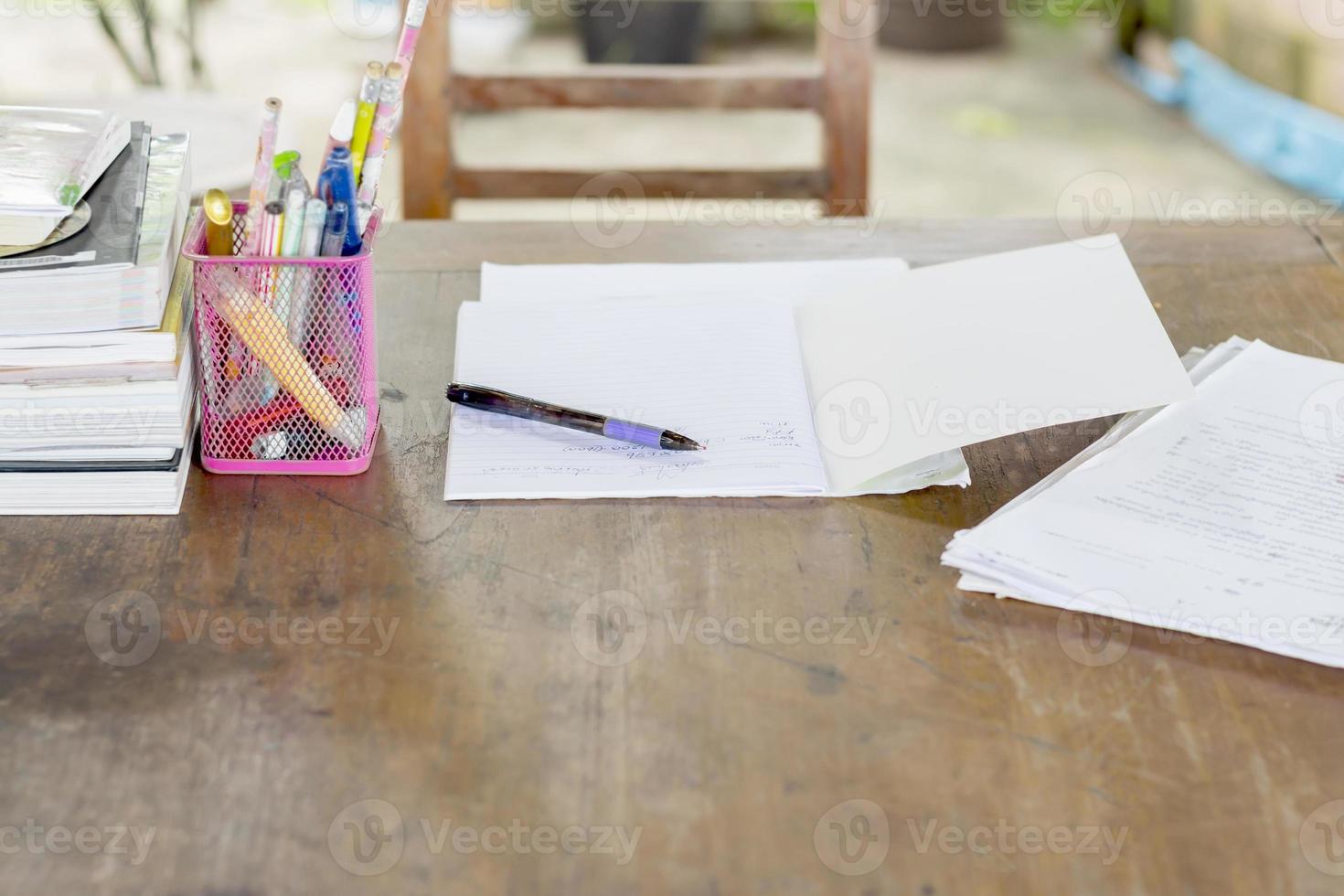 A purple ballpoint pen at the desk on top of a notebook photo