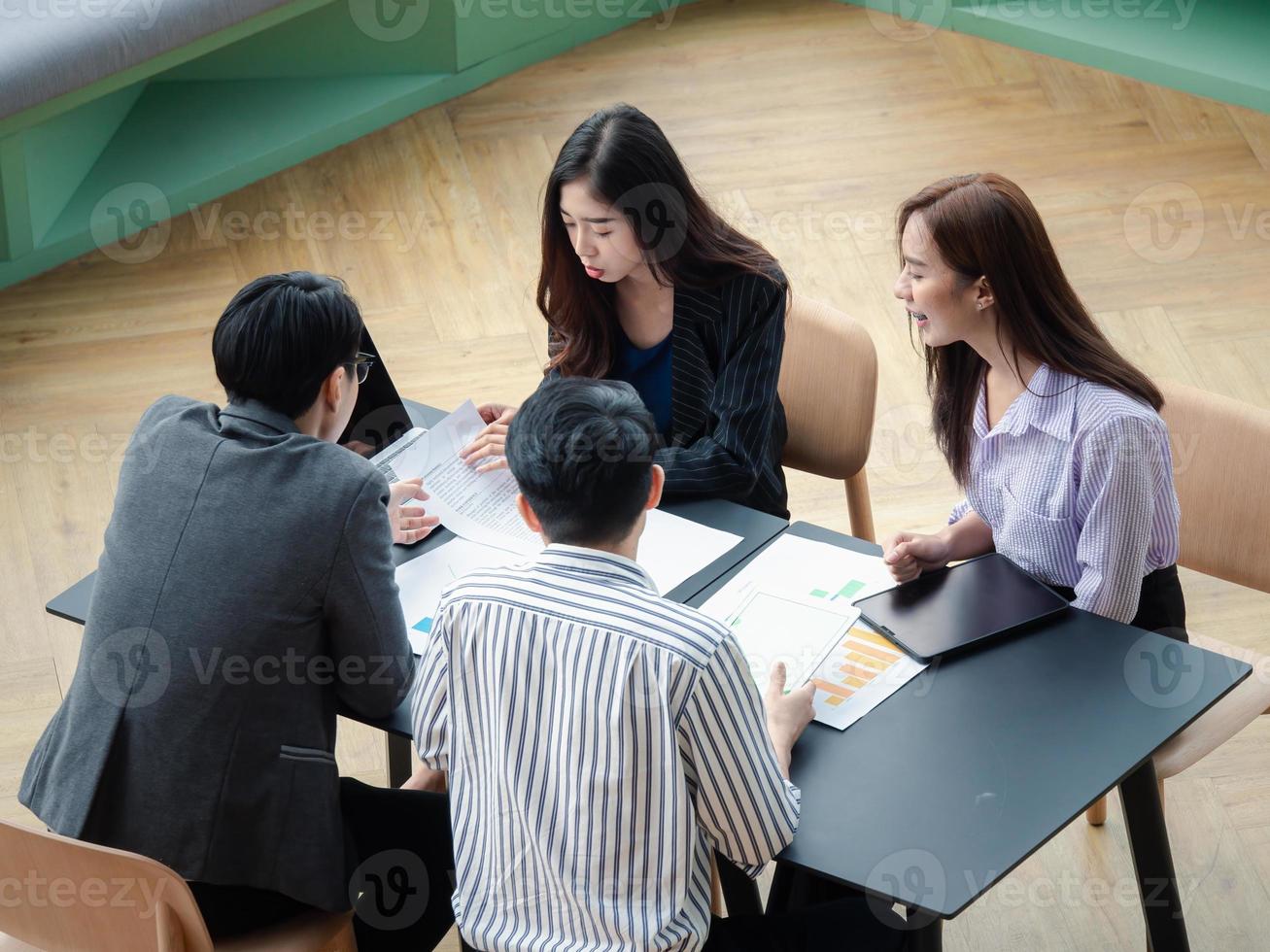 Group of Young business team discussions something while sitting at the co-working space table together, planning strategy and brainstorming, colleagues thinking concept photo