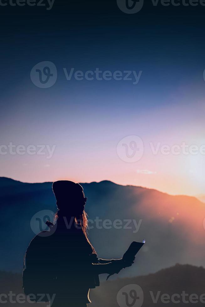 mujer joven mirando un mapa con la mañana en el fondo de las montañas. foto