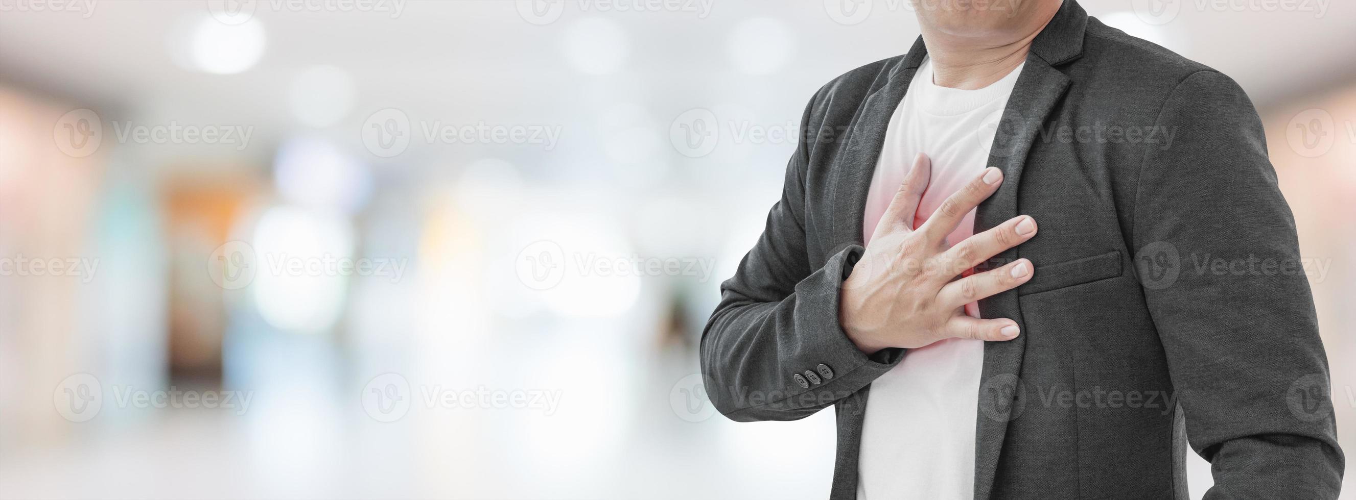 Businessman with heart attack on abstract blur hospital background. photo