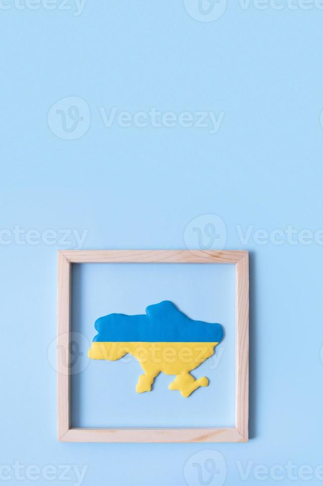 Map of Ukraine in yellow-blue colors of the Ukrainian flag in a wooden frame photo