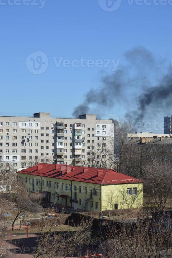 hay humo negro de la explosión de un cohete o una bomba en una ciudad durante una guerra foto