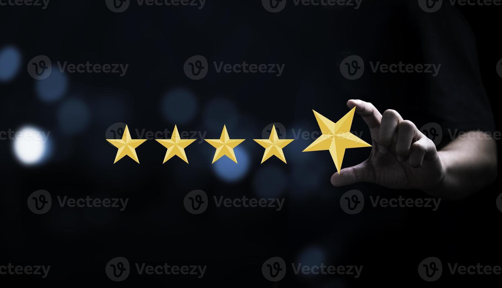 Businessman holding and input  yellow star to five stars for customer satisfaction after use product and service concept photo