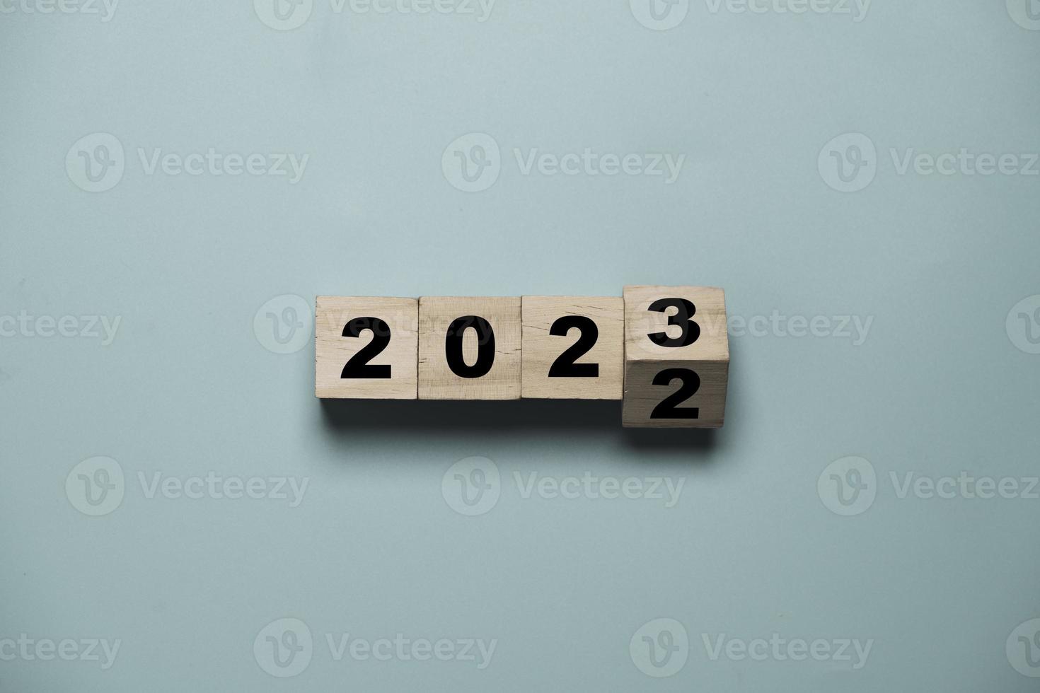 voltear de 2022 a 2023 en un cubo de bloques de madera para preparar el cambio de año nuevo y comenzar un nuevo concepto de estrategia de objetivo comercial. foto