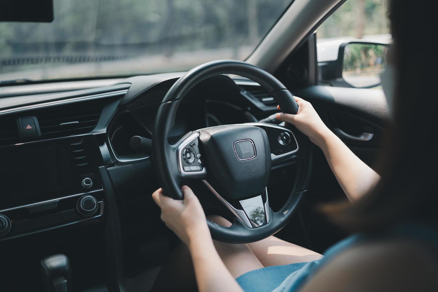 Happy asian woman wearing surgical mask while driving car. During covid-19 pandemic wearing a mask when you driving car go to outside leaving home. photo