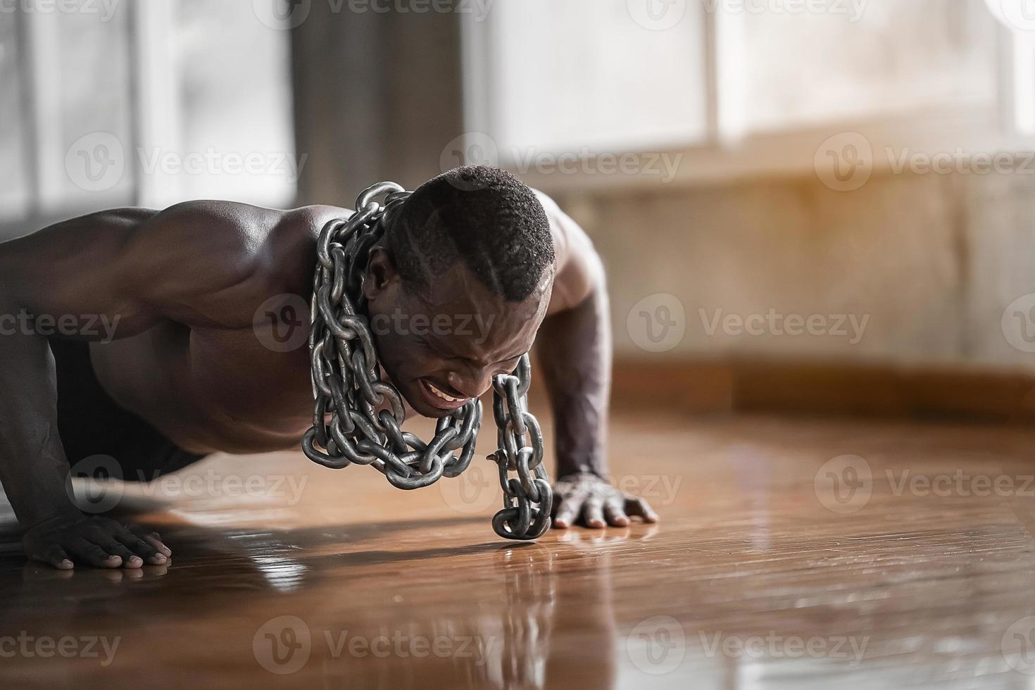 hombre africano usando cadenas haciendo ejercicio push up en el gimnasio. deporte hombre ejercicio en el gimnasio. concepto de deporte foto