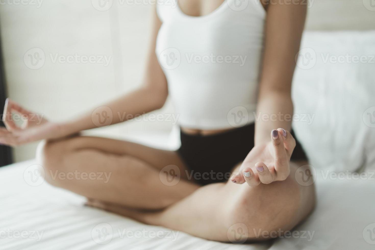 woman practicing yoga lesson, breathing, meditating, doing Ardha Padmasana exercise, Half Lotus pose with mudra gesture, working out, indoor close up. Well being, wellness concept photo