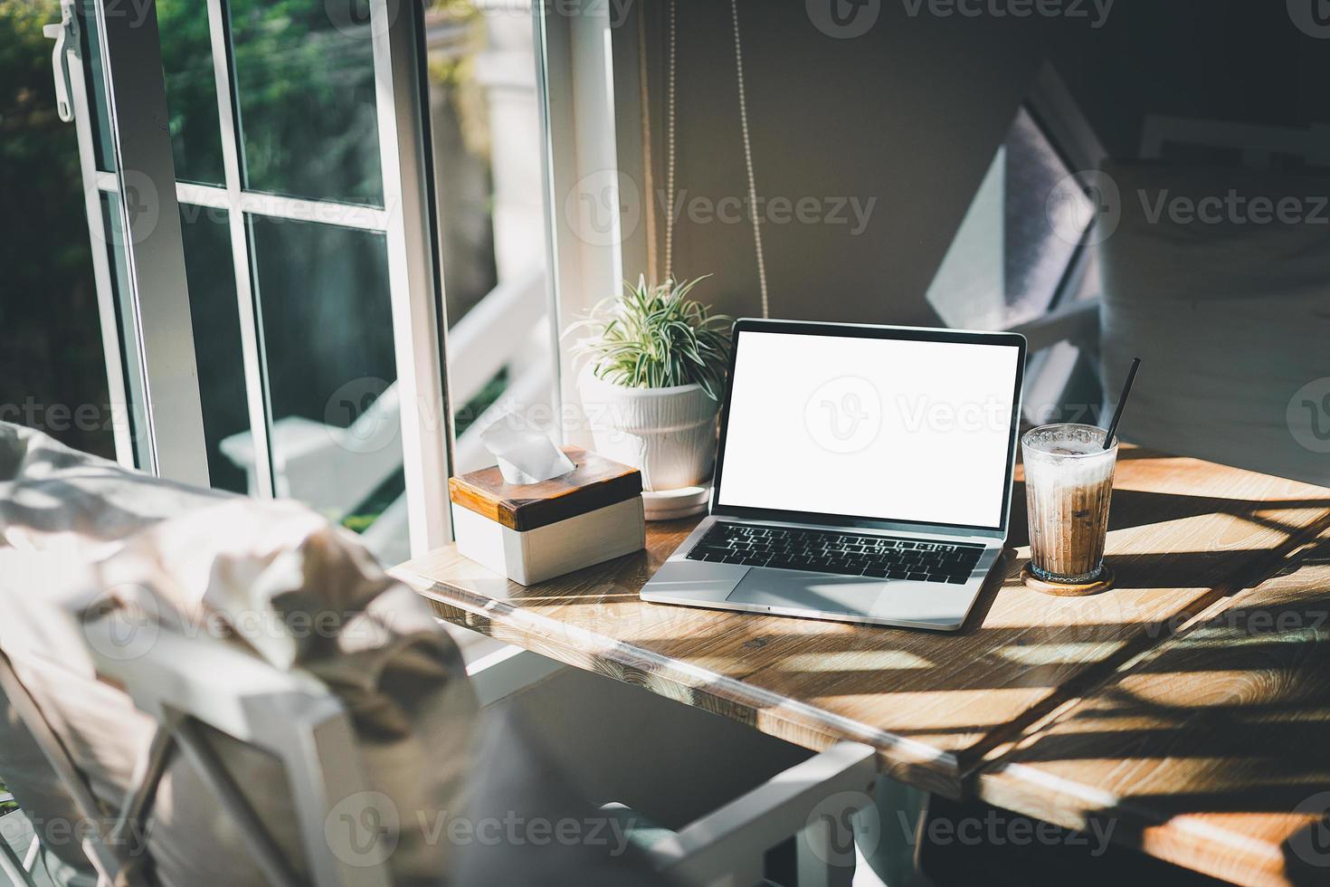 vista del espacio de trabajo portátil con el portátil sobre la mesa en el espacio de trabajo conjunto. espacio de trabajo conceptual, escritorio de espacio vacío blanco con pantalla de computadora portátil. foto