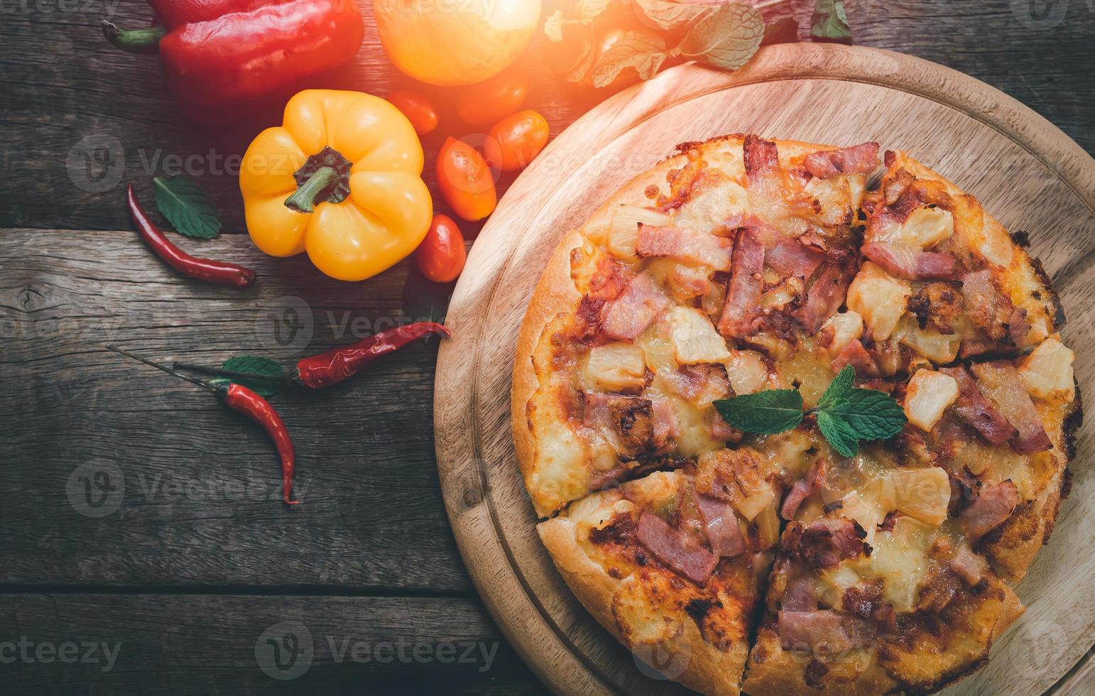 Pizza with ham, bacon, garlic and fresh herbs. Rustic style. Top view. Copy space. photo