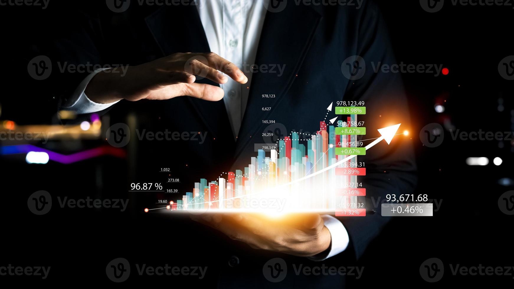 concept planning and strategy. businessman holds a tablet and displays a virtual hologram of statistics, graphs and charts with upward arrows on a dark background. stock market. Business growth. photo