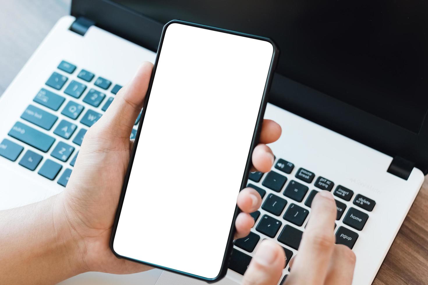 mockup copy space phone, man's hand holding smartphone with blank white copy screen for your advertising and message or information content, mobile on desk at coffee shop. photo