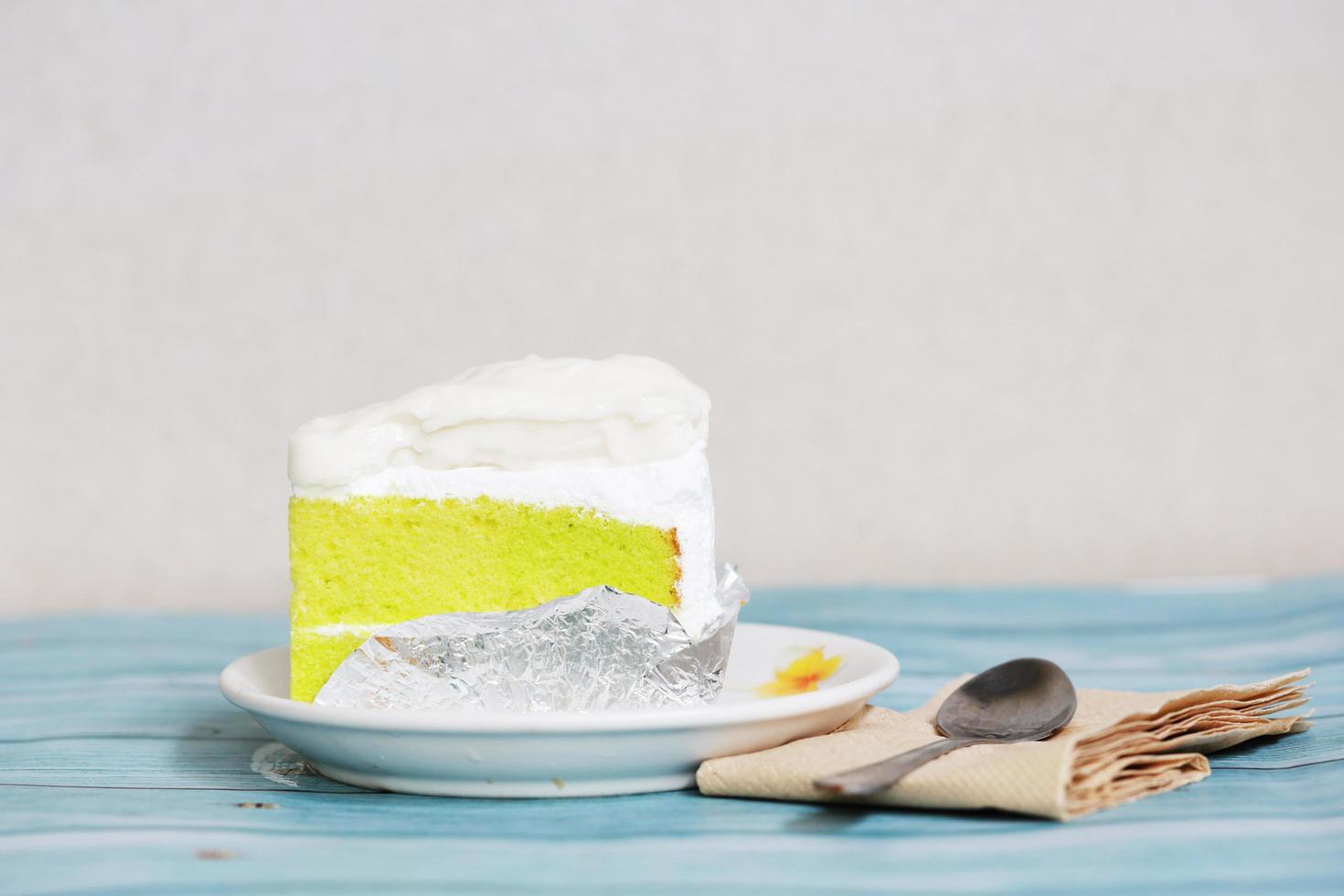 Cake coconut on the blue table homemade dessert with spoon and tissue paper photo